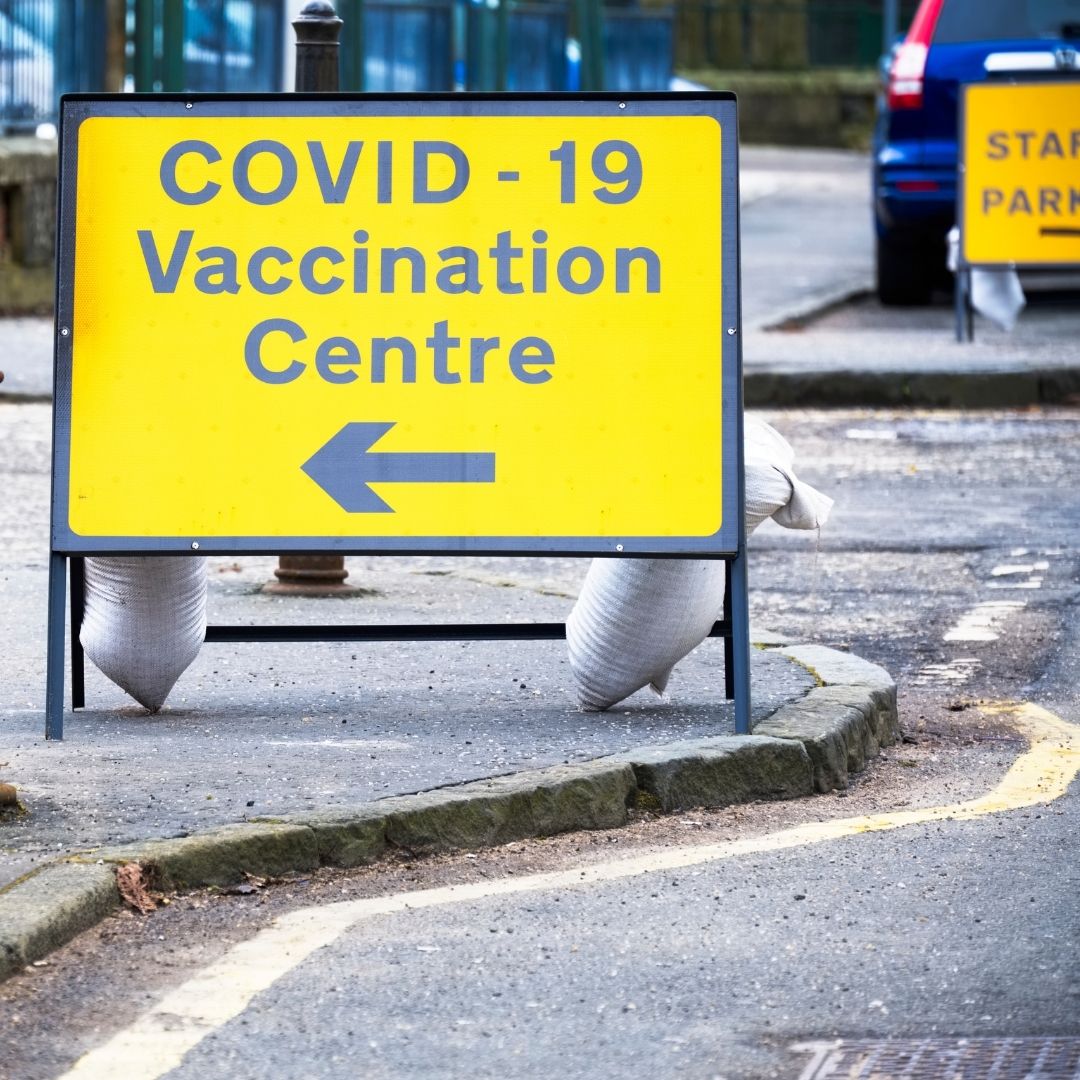 This image shows a road sign directing to a Covid 19 vaccination centre